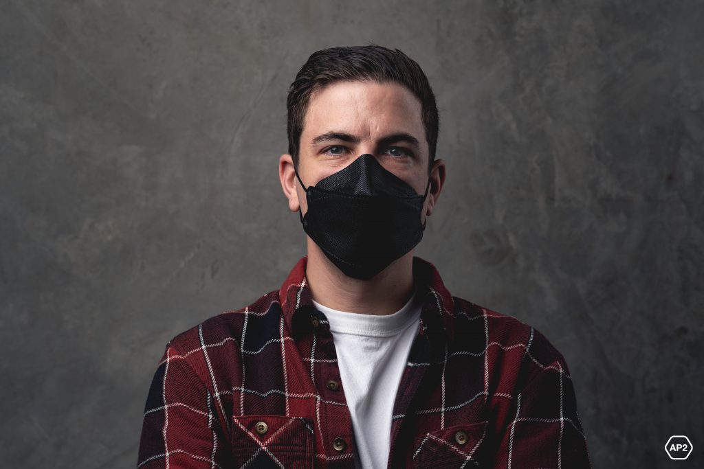 The Only Australian Made P2 Black Mask, AMD NANO-TECH Medical Respirator T4 P2 Black Worn By Caucasian Male On Distressed Concrete Background